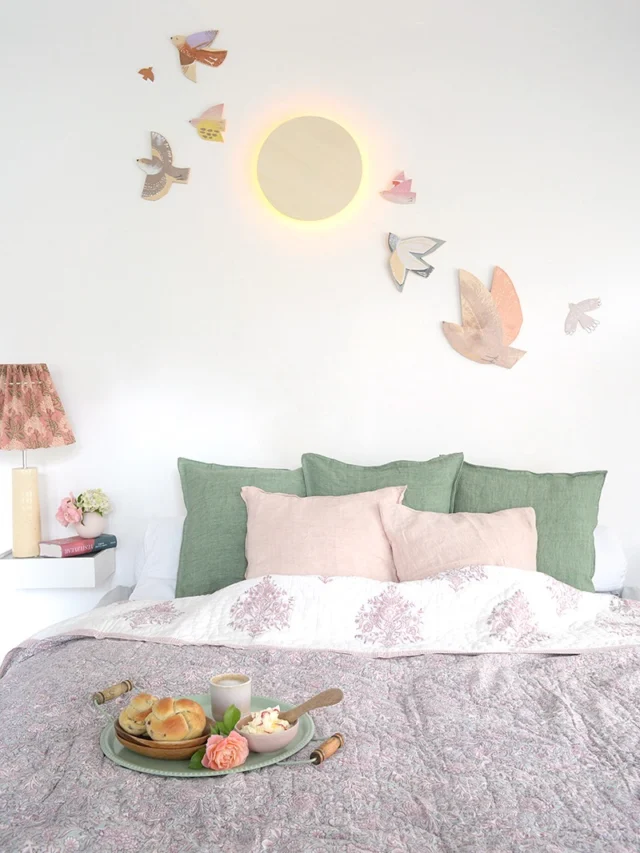 ….. #schlafzimmerdeko mit den süßen #soulbirds von @kaisu.mari 
ein make-over in meinem lieblingsraum war längst fällig!
um die diy mondlampe fliegen dekovögel und verbreiten gute vibes.

- der kuschelige #quilt von @rozabluehome hat verschiedene muster auf seinen beiden seiten. hier üppig floral in mintgrün-rosa: ein traum!
- mein ausblick ausm schlafzimmerfenster: der #suncatcher @vonlani zaubert mit seinem kristall, lichtpunkte auf fensterscheibe und boden✨
- duftet himmlisch! für einzelne blüten ist die #ballvase @cooeedesign einfach perfekt.
- mein liebstes am wochenende: frühstück im bett. dazu buch und ne blüte ausm garten. mehr brauche ich nicht.
- für gemütliche lesestunden spendet die hübsche lampe mit papierlampenschirm und keramikfuß bestes licht.

 #schlafzimmerinspiration und viele weitere dekoartikel findet ihr im #wunderschoengemachtshop